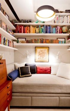 a living room filled with lots of furniture and bookshelves full of books on top of each shelf