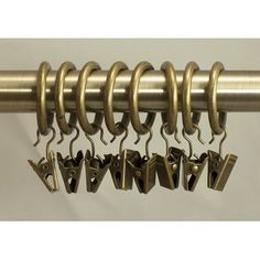 several pairs of hooks hang from a curtain rod