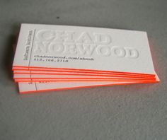 four business cards stacked on top of each other in front of a gray background with white and orange lettering