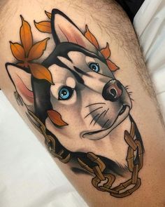 a close up of a person's leg with a cat tattoo on it and chains