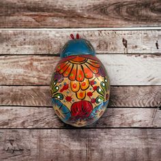 a painted egg sitting on top of a wooden table