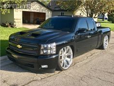 a black truck is parked in front of a house