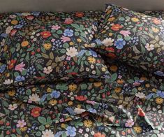 an image of a bed with flowers on the comforter and pillow cases in it