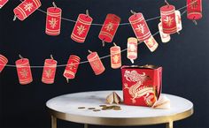 red paper lanterns are hung on a string over a table with gold coins and other decorations