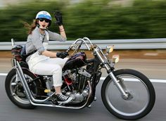 a woman riding on the back of a motorcycle