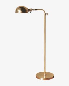 a brass plated floor lamp with a wooden base and an arm, on a white background