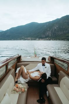 a man and woman sitting on the back of a boat