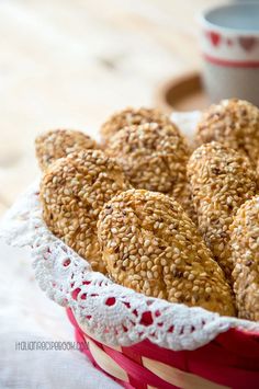 sesame seed pastries in a basket with a cup of coffee