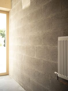 an empty room with a radiator on the wall and sunlight coming through the window