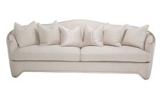 a white couch with lots of pillows on it's back and arms, in front of a white background