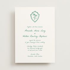 a green and white wedding card with palm trees in the background on a white surface