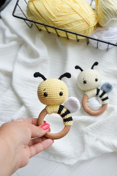 two crocheted bee rings being held by someone