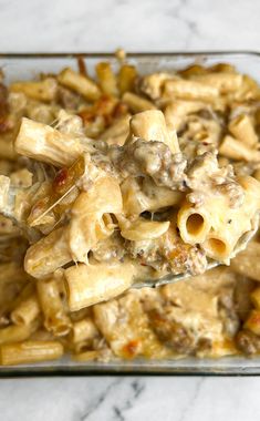 a glass casserole dish filled with pasta and meat