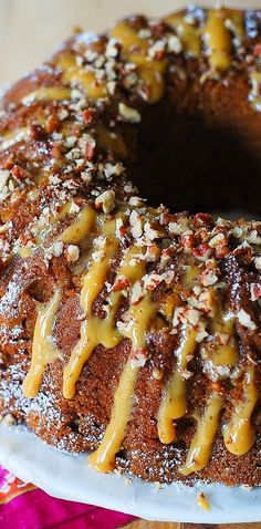 a bundt cake covered in caramel drizzle and nuts