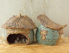 two ceramic houses are sitting on a table