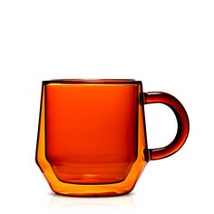 an orange glass cup sitting on top of a white table