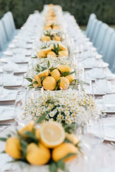 a long table with lemons and baby's breath flowers