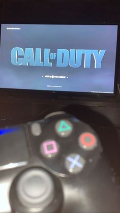 a video game controller sitting in front of a tv with the word call of duty on it