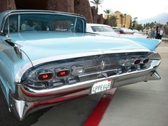 an old blue car is parked on the street