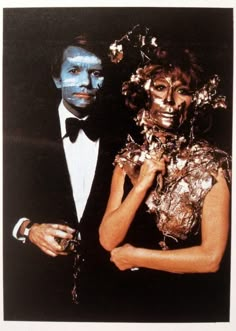 a man and woman dressed in costumes pose for a photo with their faces painted blue