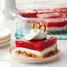 a piece of red velvet dessert on a plate with pretzels and whipped cream