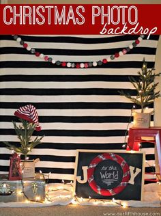 christmas photo backdrop with holiday decorations and lights in front of a black and white striped wall