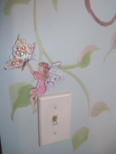 a little fairy sitting on top of a light switch