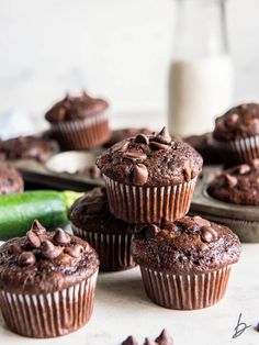 chocolate zucchini muffins stacked on top of each other with the title overlay