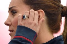 a close up of a person with a ring on their finger and wearing a jacket