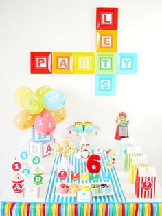 a party table with balloons, cupcakes and other items for a child's birthday