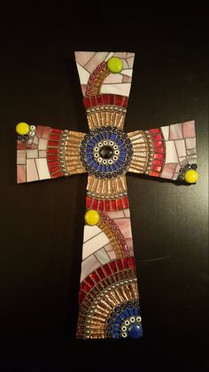 a cross made out of stained glass and beads