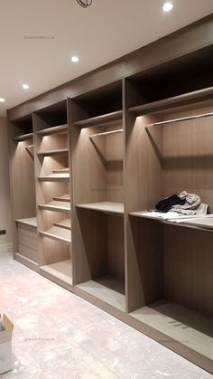 an empty walk in closet with wooden shelves