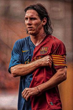 a man with long hair standing on top of a soccer field