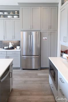 a stainless steel refrigerator in a white kitchen