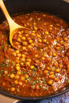 a wooden spoon in a pot filled with chickpeas