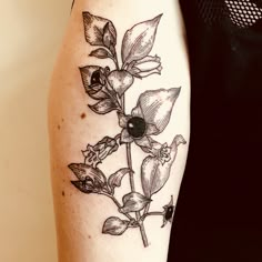 a black and white photo of a flower on a woman's right arm,