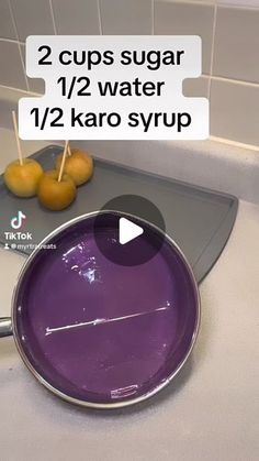 a purple pan sitting on top of a counter next to oranges and a knife