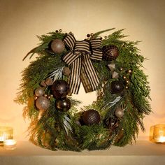 a christmas wreath with ornaments and candles