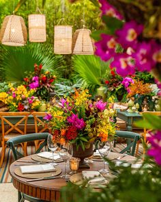 an outdoor dining area with tables, chairs and flowers in vases on the table