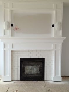 an empty fireplace with white painted brick surround