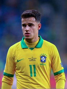 the soccer player is wearing a yellow shirt with green trims on his head and looking at the camera