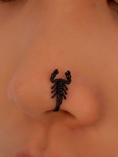 a scorpion tattoo on the side of a woman's nose is seen in this image