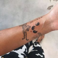 a woman's arm with tattoos on it and an animal drawn on the arm