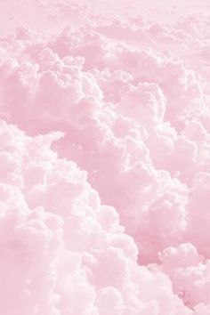 the sky is filled with fluffy clouds and pink hues, as seen from above