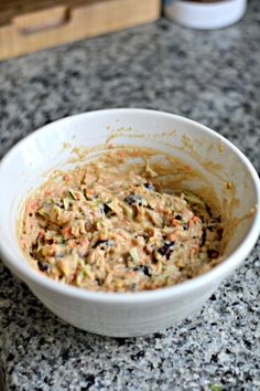 a white bowl filled with food sitting on top of a counter