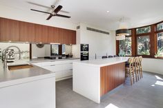 a large kitchen with an island counter and wooden cabinets