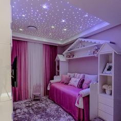 a purple and white bedroom with stars on the ceiling, pink bedding and curtains