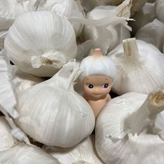 there is a small figurine in the middle of some garlic