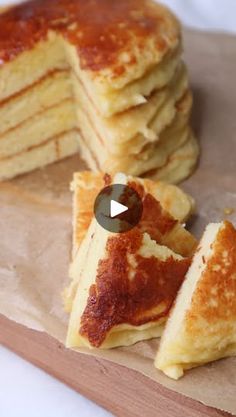 a stack of pancakes sitting on top of a wooden cutting board