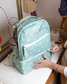 a woman sitting at a table with a blue backpack